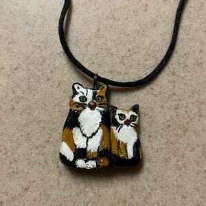 Vintage hand-painted enameled calico cat pendant necklace on a black cord